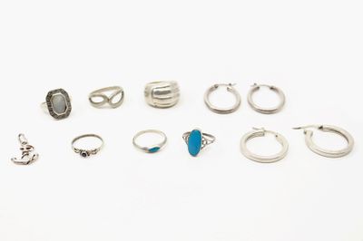 plusieurs bagues et boucles d'oreilles différentes posées sur une surface blanche