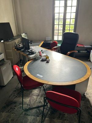 des tables et des chaises dans une pièce dotée d'une grande fenêtre et d'une télévision