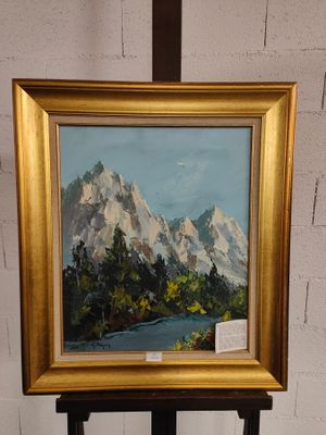 un tableau représentant un paysage de montagne, dans un cadre doré