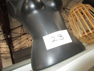 un mannequin noir sur lequel est apposée une étiquette blanche