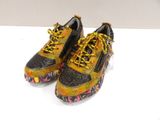 pair of black and yellow sneakers with yellow laces on them