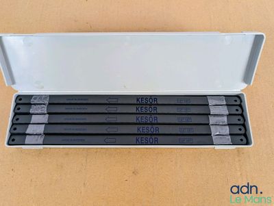 trois crayons noir et blanc dans un étui en plastique posé sur une table
