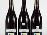 trois bouteilles de vin sont alignées sur une surface blanche