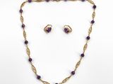 un ensemble composé d'un collier et de boucles d'oreilles en or, orné de perles d'améthorate