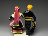 two figurines of a man and a woman dressed in black and pink