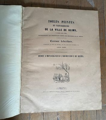 un vieux livre posé par terre, avec l'image d'un chat