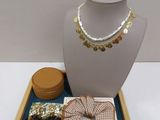 a necklace, bracelets, and other jewelry on a tray