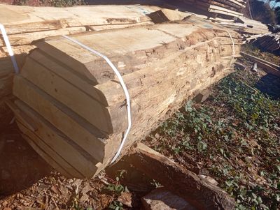 plusieurs morceaux de bois sont empilés dans une cour