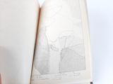 a person holding an open book with a map on it