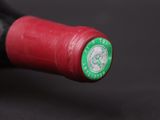 a close up of a bottle of wine with a red cap
