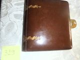 un livre en cuir marron orné d'une inscription dorée