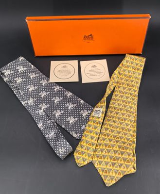 Deux cravates et une boîte orange sont posées sur une table