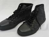 une paire de baskets noires sur fond blanc