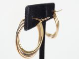 a close up of a pair of gold hoop earrings on a black stand