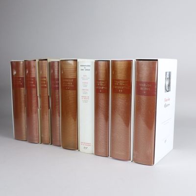 several books are lined up in a row on a white surface