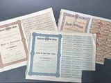 several old certificates are displayed on top of each other on a table