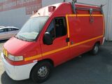 a red and yellow van parked in front of a building