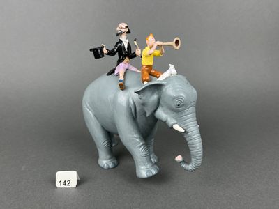 figurines représentant deux personnes chevauchant un éléphant qui barrit