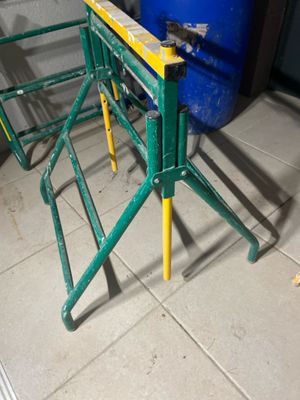 a green table with yellow legs on a tiled floor