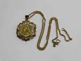 Gros plan sur un collier en or sur lequel se trouve une pièce de monnaie