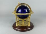 une boule de verre bleue posée sur un socle en bois