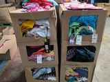 Des cartons de vêtements sont empilés les uns sur les autres dans un entrepôt