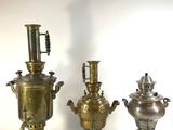 three antique brass urns and a silver vase on a white background