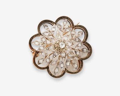 un gros plan d'une broche en forme de fleur sur fond blanc