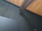 une photo d'une salle de bains avec un sol noir et un plafond en bois