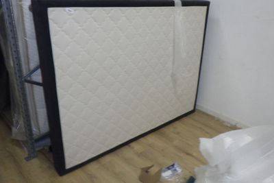 un lit avec un matelas posé dessus dans une chambre