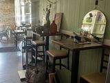 Dans un restaurant où un miroir est accroché au mur, des tables et des chaises sont alignées.
