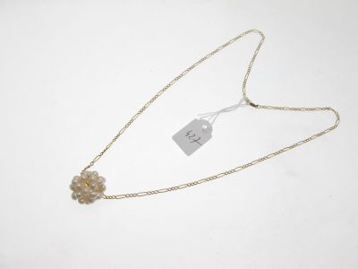 a close up of a necklace on a white surface with a price tag