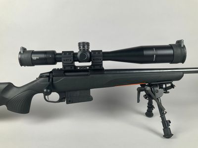 a rifle on a tripod with a scope on it