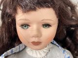 a close up of a doll wearing a blue and white checkered dress