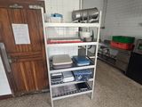 une cuisine équipée d'une cuisinière, d'un réfrigérateur, d'un évier et d'étagères