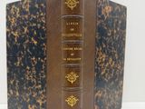 un vieux livre posé sur une table blanche à côté d'un mur blanc