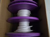 une boîte contenant tout un tas de bobines violettes et blanches