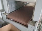 a box that is sitting on the floor next to a machine that has a roll of paper on it