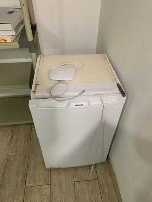 une photo d'un petit réfrigérateur blanc dans une petite pièce