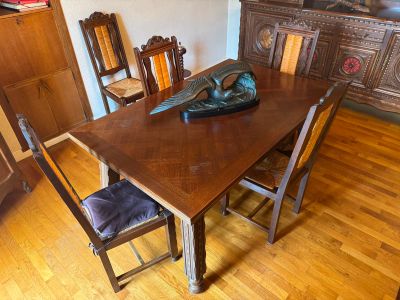 a wooden table with chairs and a vase on top of it