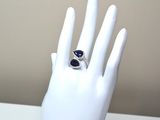 une main sur laquelle est passée une bague sertie d'une pierre bleue