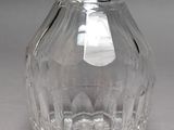 a clear glass bottle with a handle on a table