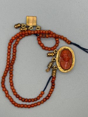 un gros plan d'un collier de perles orné d'un médaillon