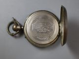 a small silver pocket watch with a chain around it