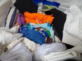 une pile de vêtements posée sur un lit