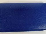 un gros plan d'un sac à main bleu posé sur une surface blanche