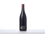 the bottle of wine is sitting on the table on a white surface