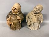 deux statues représentant un moine et un moine tenant un bébé dans ses bras