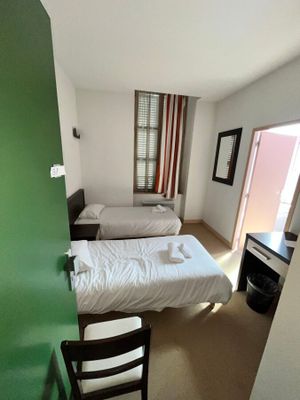 une chambre avec deux lits et un bureau