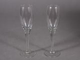 two empty wine glasses sitting on a table with a gray background